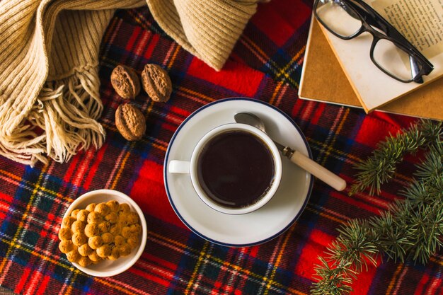 Sciarpa e libri vicino a tè e snack