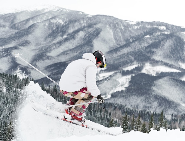Sciatore che indossa l'attrezzatura da sci che trascorre del tempo sui pendii di montagna nella stagione invernale