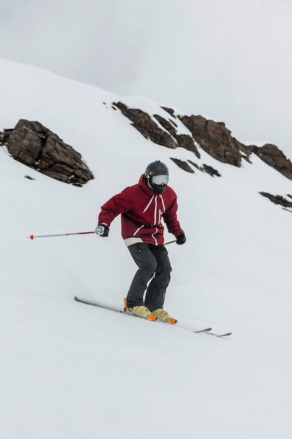 Sciatore del colpo pieno che tiene i bastoncini da sci