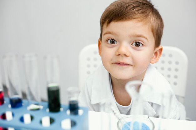 Scienziato di giovane ragazzo carino con provette facendo esperimenti