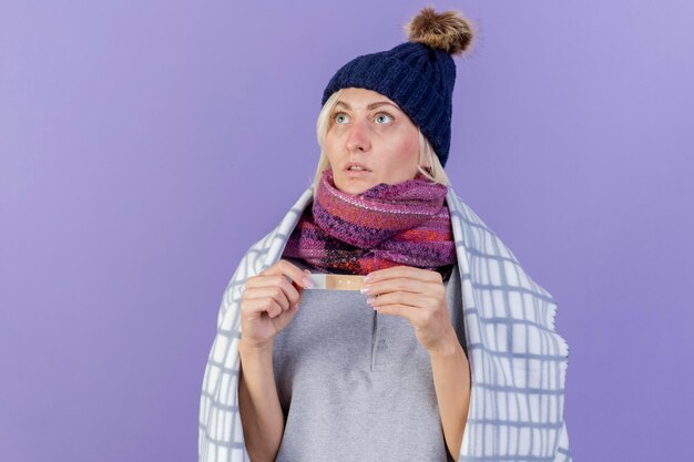 Scioccato giovane bionda malata donna slava che indossa sciarpa e cappello invernale