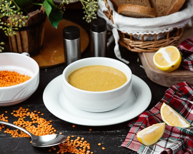 scodella di zuppa di lenticchie servita con fettine di limone