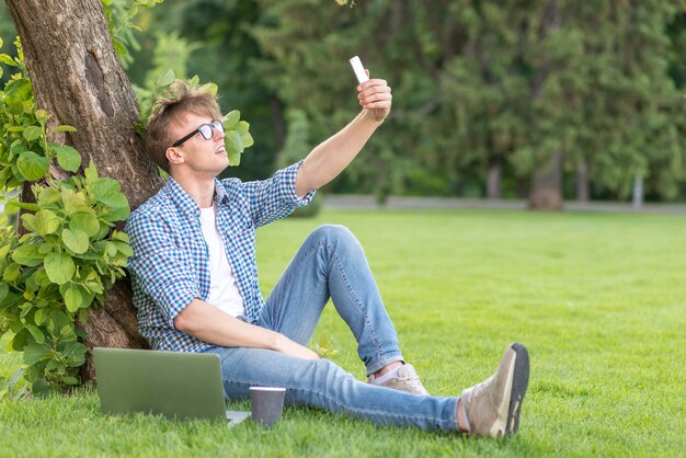 Scolaro che prende selfie nel parco