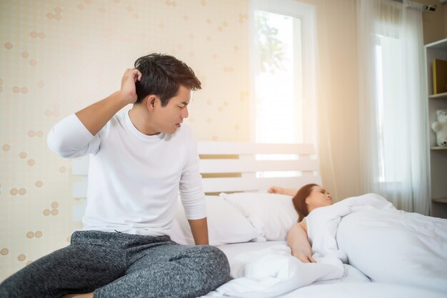 Sconvolto l&#39;uomo avendo problemi seduto sul letto dopo aver litigato con la sua ragazza