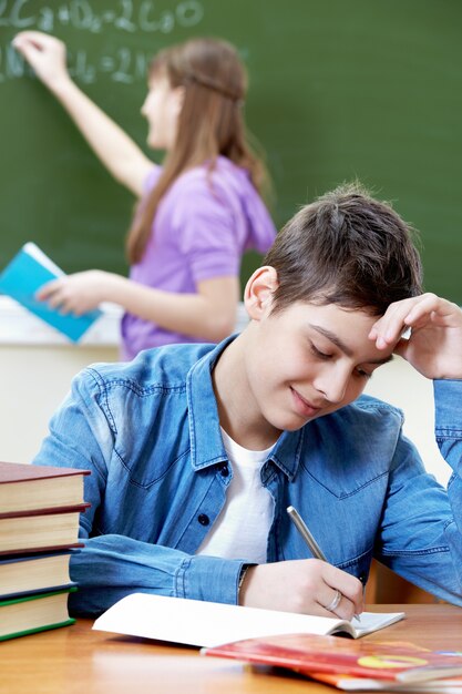 scrittura degli studenti e toccando la fronte