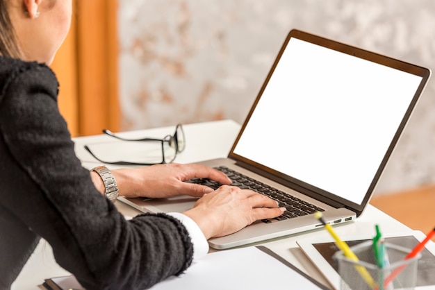 Scrittura della donna di affari del Brunette sul computer portatile