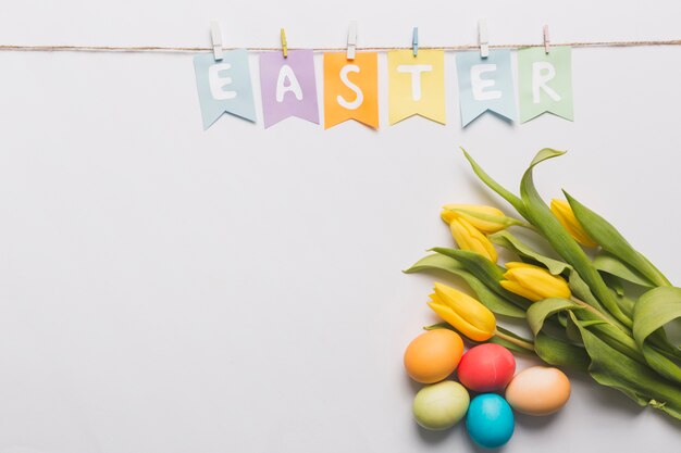 Scrittura di Pasqua vicino a tulipani e uova