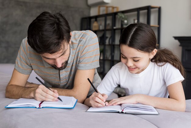 Scrittura padre e ragazza di alto angolo