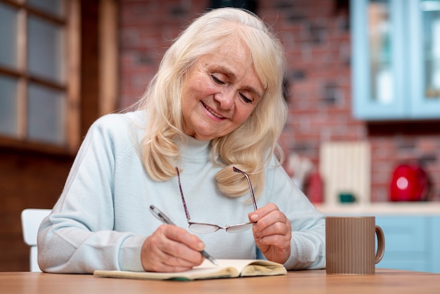 Scrittura senior della donna di angolo basso nell'ordine del giorno