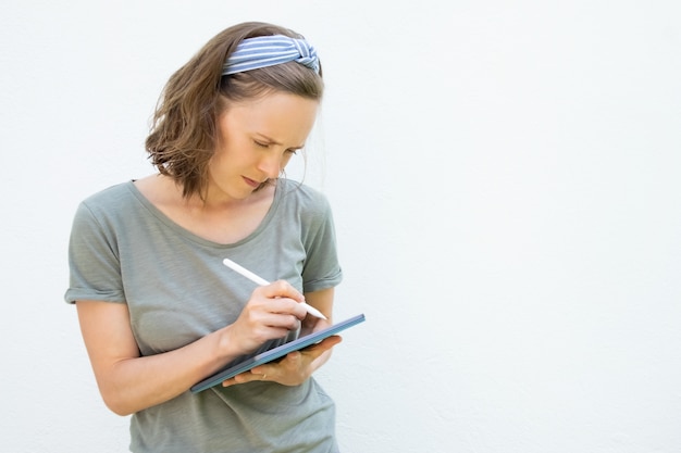 Scrittura seria focalizzata sullo schermo del tablet