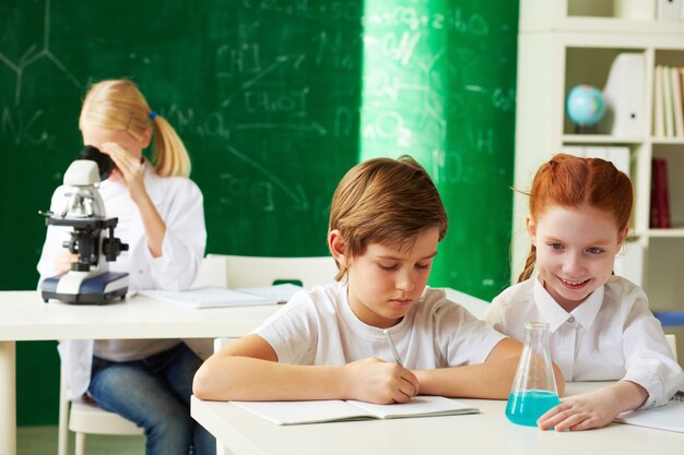 scrittura seria scolaro nel suo taccuino in laboratorio