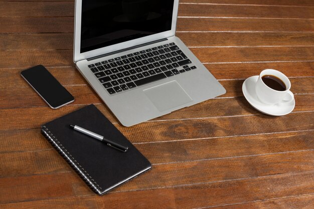 Scrivania con computer portatile, blocco note e una tazza di caffè