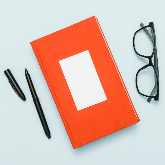 Scrivania da ufficio con libro, occhiali e penna