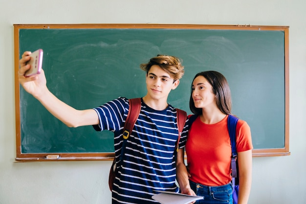 Scuole di scuola che prendono selfie in aula