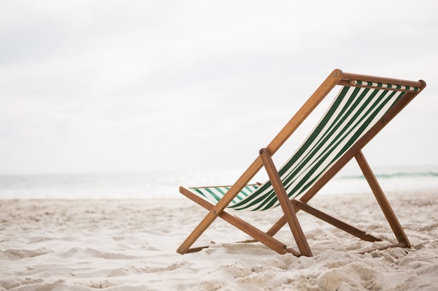 Sedie a sdraio sulla spiaggia di sabbia tropicale