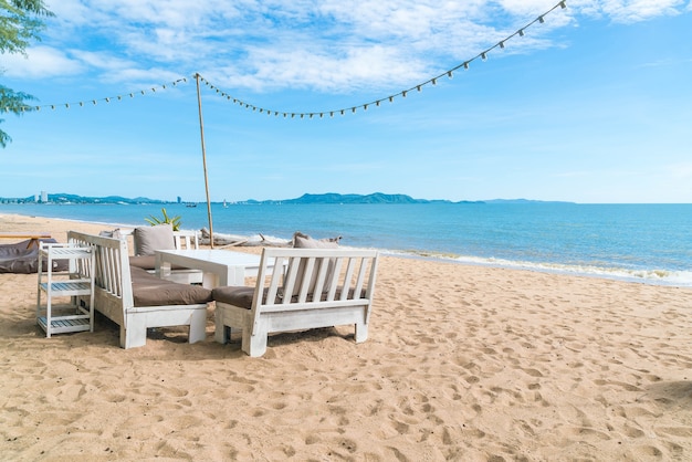 Sedie bianche e tavola sulla spiaggia