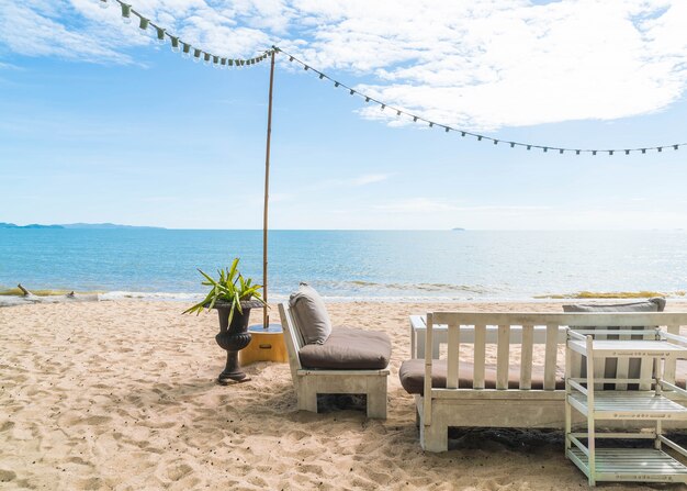 Sedie bianche e tavola sulla spiaggia