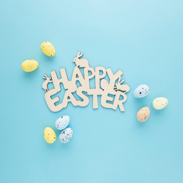Segno di legno felice di Pasqua con le uova su una priorità bassa blu