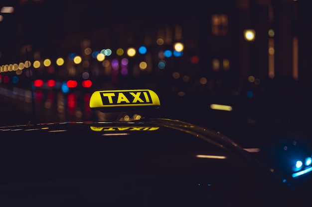 Segno di taxi in auto durante la notte