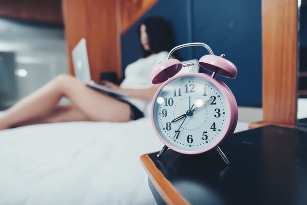 Seleziona l&#39;orologio Focus con una bella donna che lavora sul letto