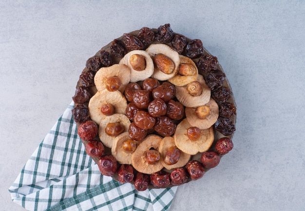 Selezione di frutta secca su un piatto su una superficie di cemento.