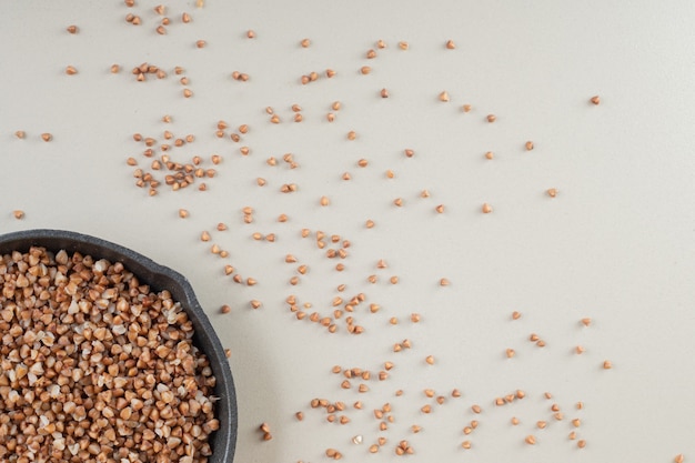 Semi di grano saraceno in un piatto su cemento.