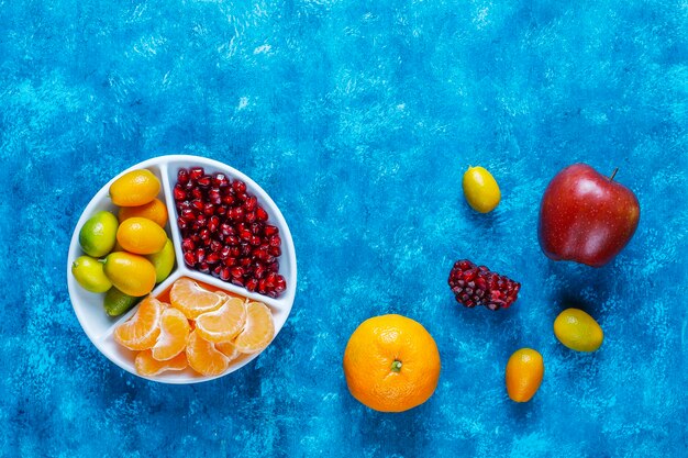 Semi freschi di melograno, fette di mandarini e frutti di kumquat.