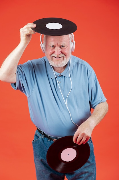 Senior dell'angolo alto che gioca con i dischi di musica