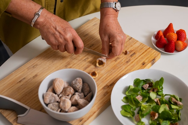 Senior donna che fa il piatto con i fichi in cucina