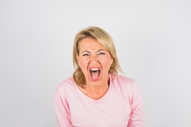 Senior donna che grida in camicetta rosa