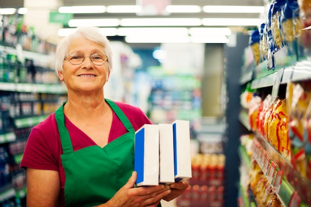 Senior donna che lavora al supermercato