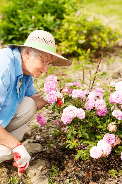 Senior donna con fiori in giardino