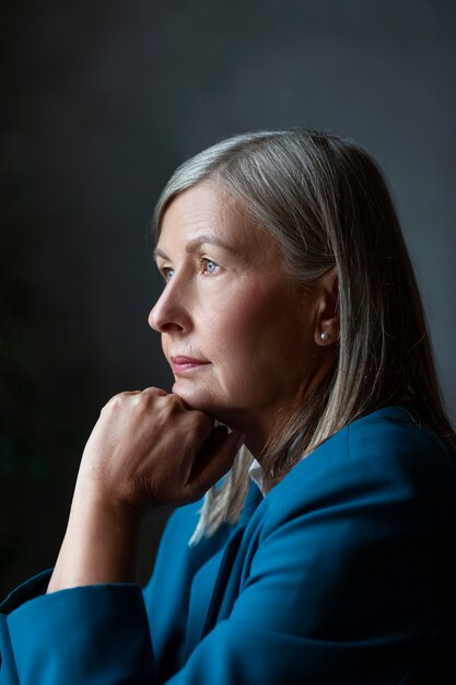 Senior donna in posa all'interno vista laterale