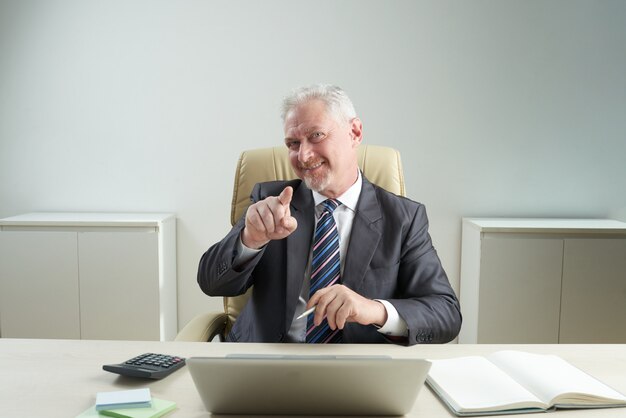 Senior Manager bello che indica alla macchina fotografica