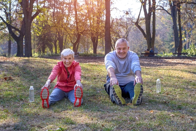 Senior maschi e femmine che si esercitano nel parco in autunno