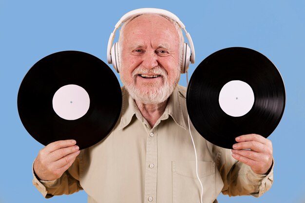 Senior maschile felice di avere dischi musicali