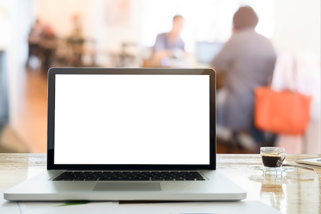 Sensazione di rilassarsi laptop sulla scrivania in sala di lavoro caffè caffè con luce di mattina e sfocatura sfondo di discussione team.