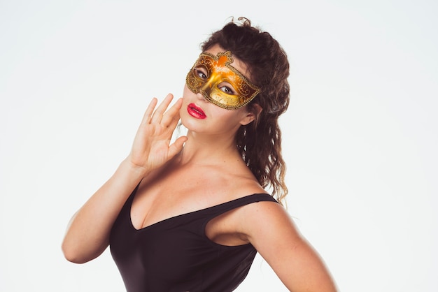 Sensuale donna graziosa in maschera d&#39;oro