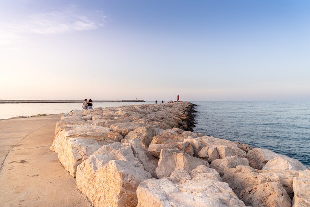 Sentiero verso il faro in lontananza sotto un cielo blu