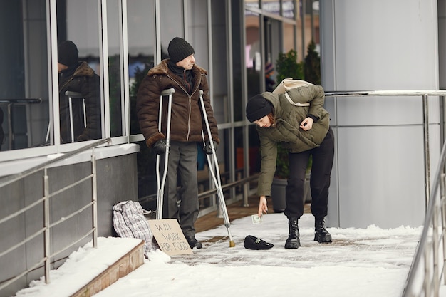 Senzatetto in una città invernale. Uomo che chiede cibo.