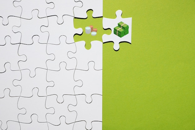 Separazione di monete e banconote su puzzle su sfondo verde