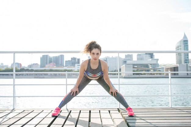 Serio sportivo donna esercitare sul ponte della città