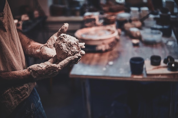 Servizio fotografico in primo piano del processo di lavorazione con argilla da parte di un uomo diligente.