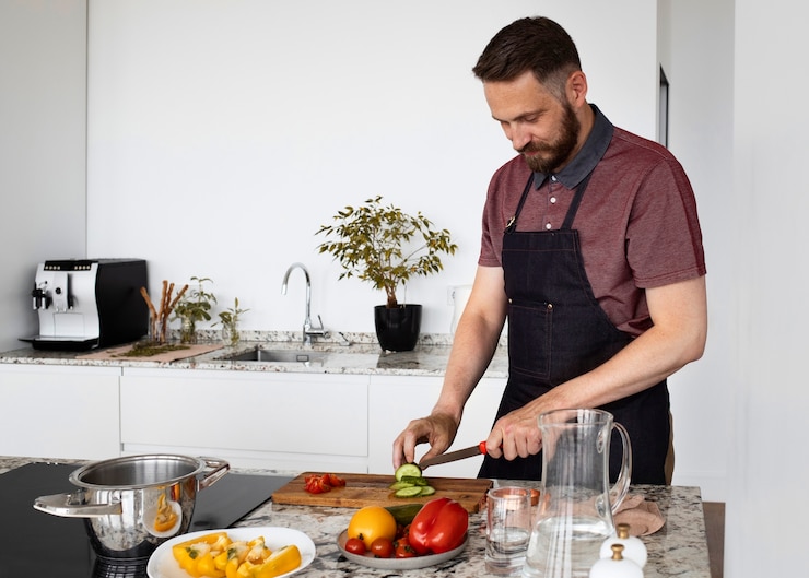 Foto gratuito servo uomo che cucina in cucina