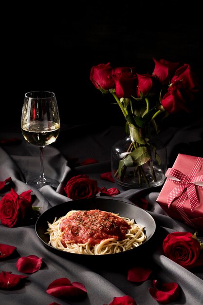 Set da tavola di San Valentino con pasta e bouquet di rose