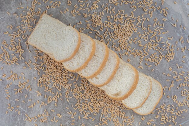 Set di fette di pane tostato con chicchi di avena sulla superficie in marmo