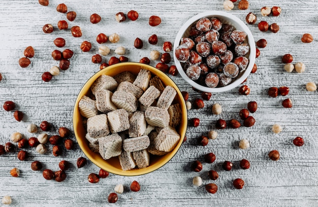 Set di nocciole e cialde in ciotole su un legno chiaro