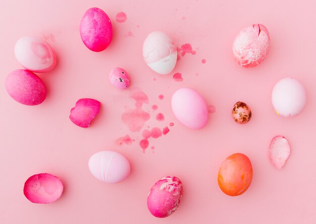 Set di rose e bianche uova di Pasqua tra spruzzi di liquido colorante