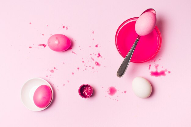 Set di rose uova di Pasqua tra macchie, cucchiaio e liquido di tintura