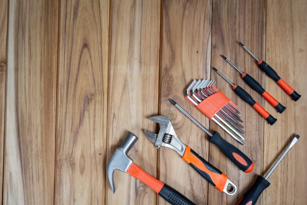 Set di strumenti manuali, impostato sul pavimento di legno.